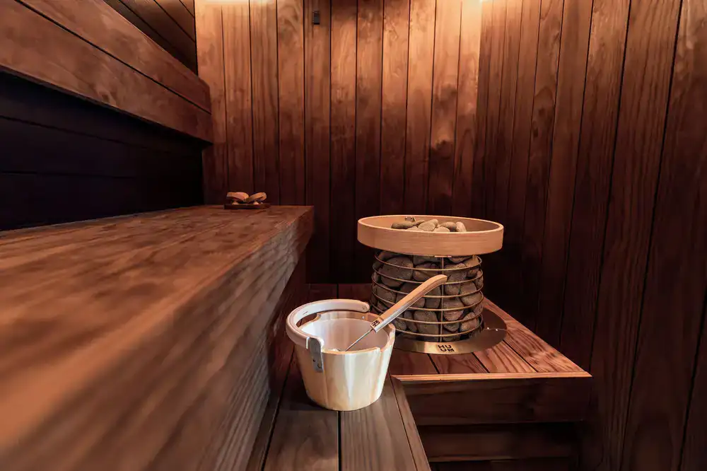 Atmospheric bespoke sauna interior with warm honey pine lighting
